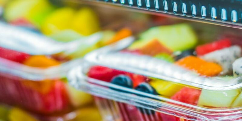 plastic containers filled with fruit at grocery store